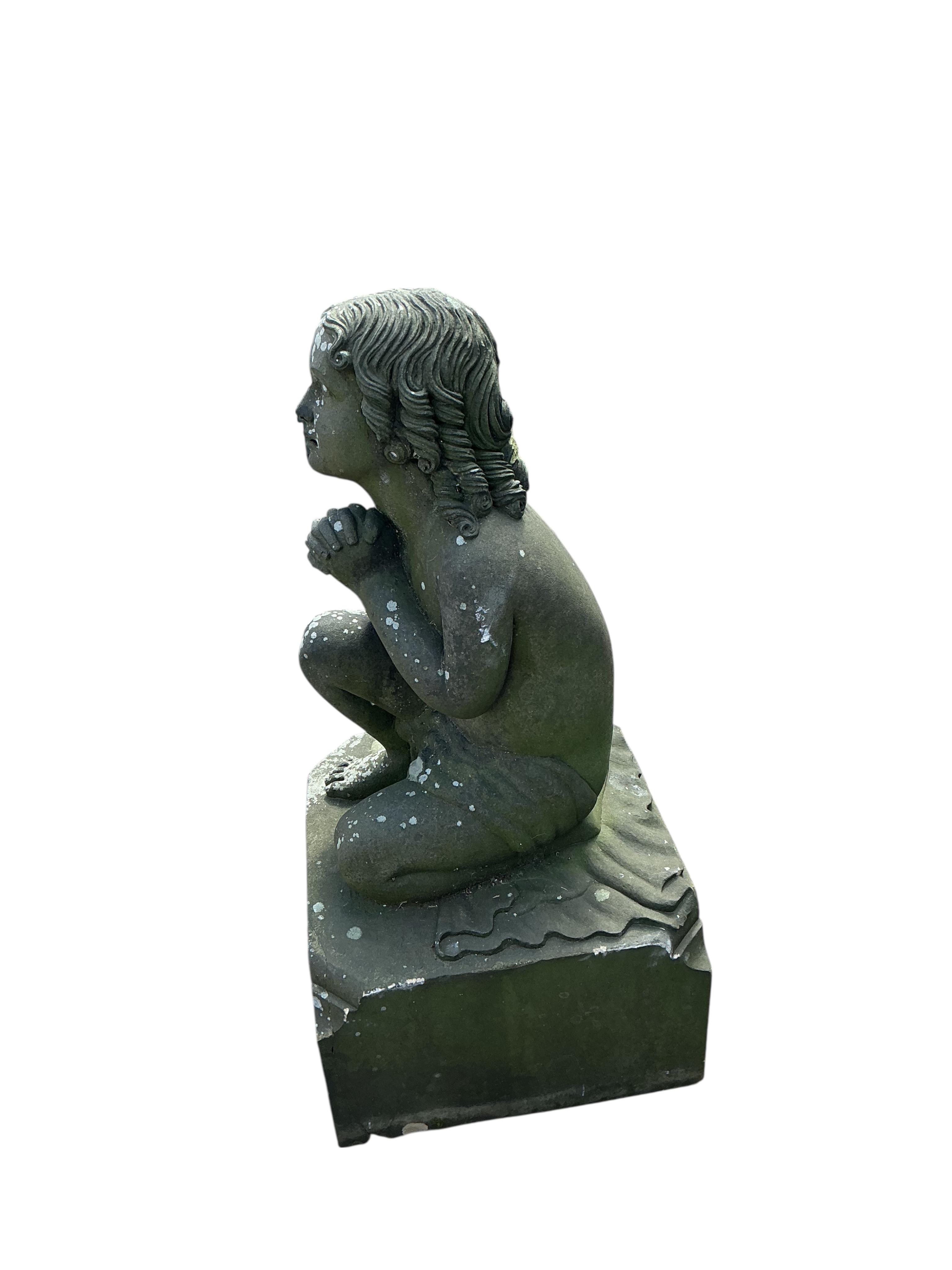 A stone garden ornament of a kneeling child at prayer, height 95cm